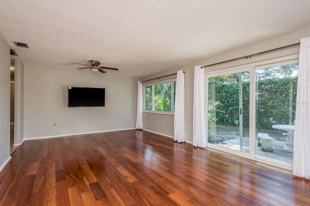 1104 Carlton Road Tarpon Springs, FL 34689 - Photo 19 of 35 a view of empty room with wooden floor and fan