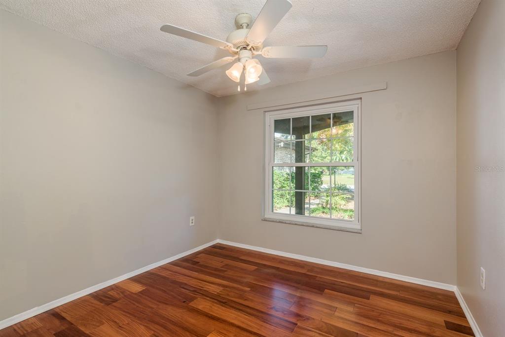1104 Carlton Road Tarpon Springs, FL 34689 - Photo 29 of 35 a view of an empty room with wooden floor and a window