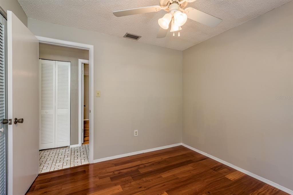 1104 Carlton Road Tarpon Springs, FL 34689 - Photo 30 of 35 an empty room with wooden floor and fan