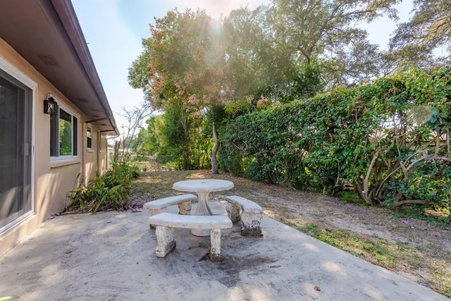 a view of a patio with table and chairs and potted plants