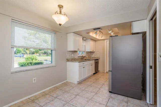 a kitchen with granite countertop a refrigerator and a sink