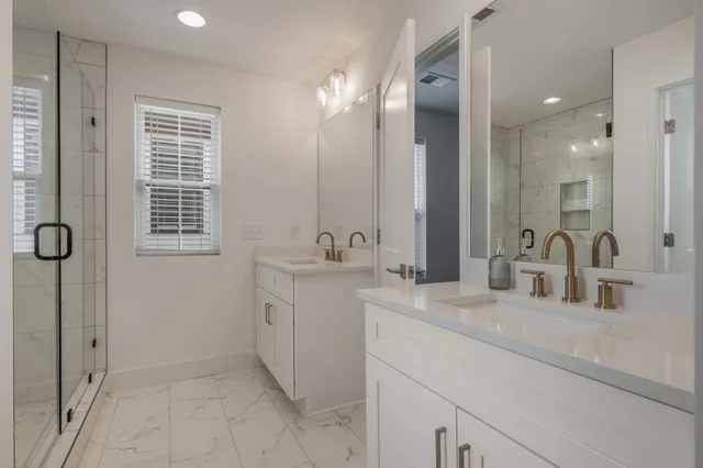 a bathroom with a double vanity sink a mirror and a shower