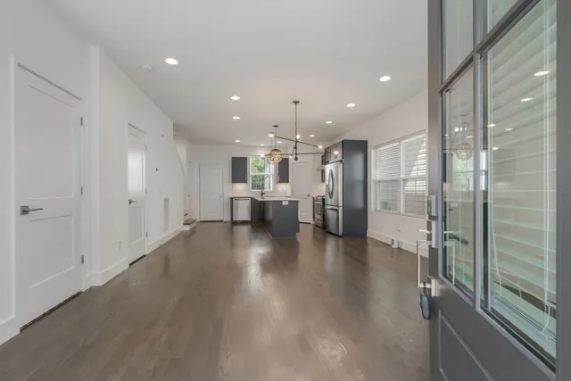 a view of a big room with wooden floor and windows
