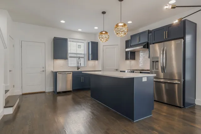 a kitchen with kitchen island a sink stainless steel appliances and cabinets
