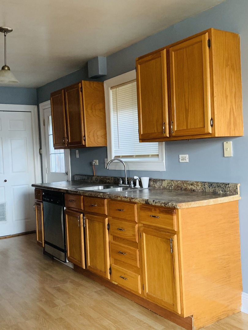 5230 State Road Burbank, IL 60459 - Photo 5 of 26 a kitchen with granite countertop wooden cabinets a sink and a window
