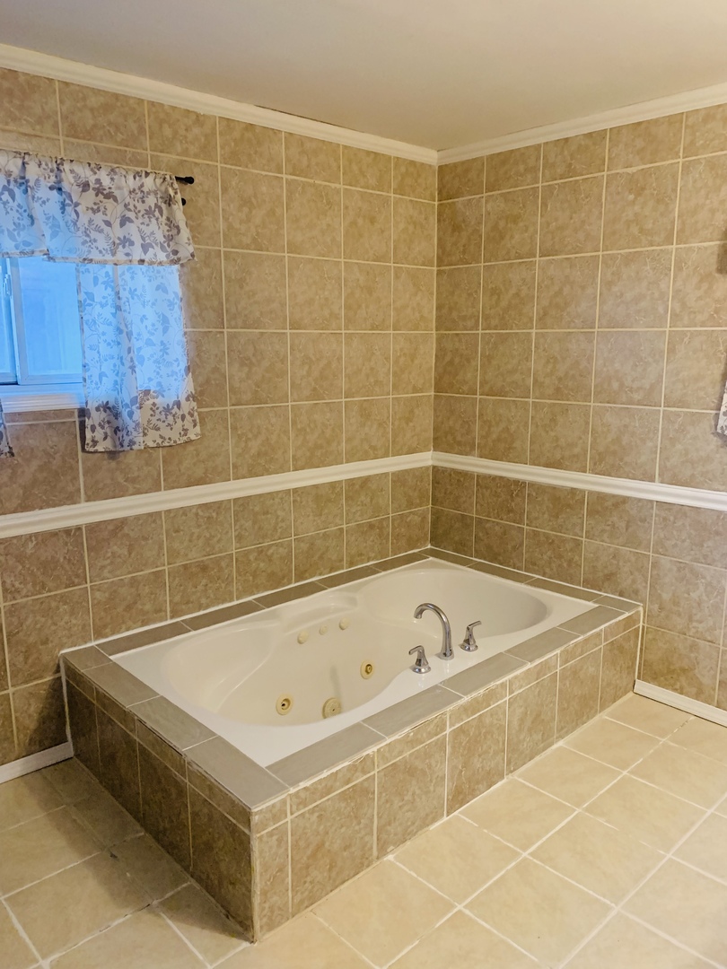 5230 State Road Burbank, IL 60459 - Photo 10 of 26 a bathroom with a bathtub and shower