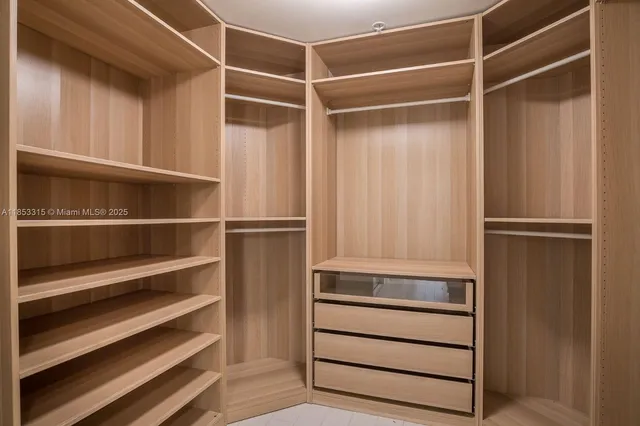 a view of walk in closet with empty racks