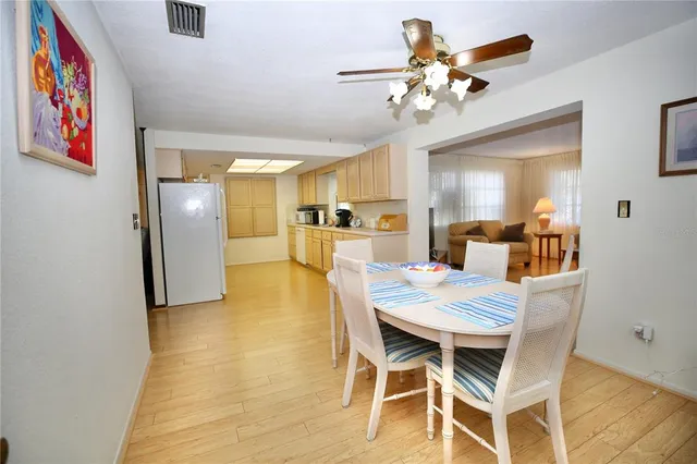 a view of a dining room with furniture and a chandelier fan