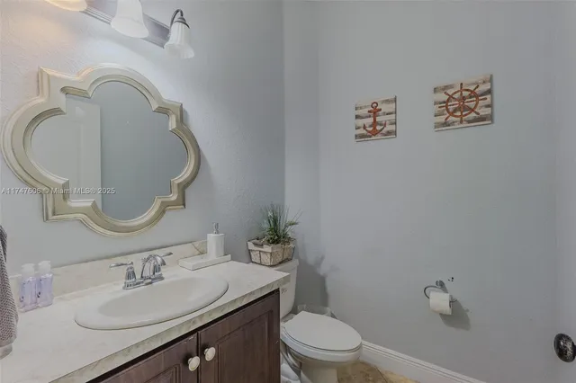 a bathroom with a sink vanity mirror and toilet