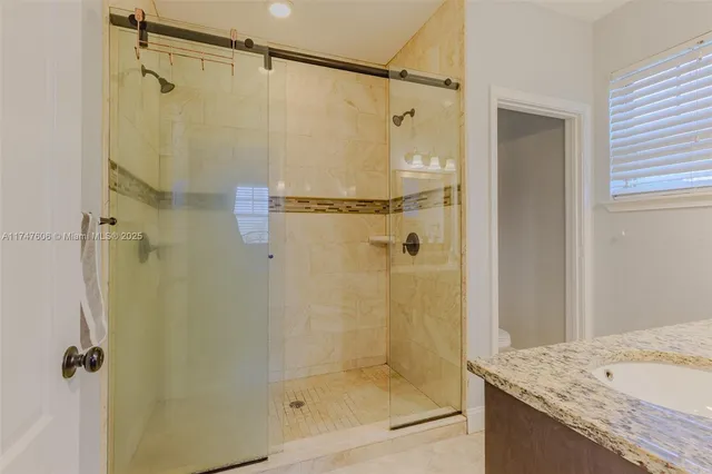 a bathroom with a granite countertop shower mirror and a sink
