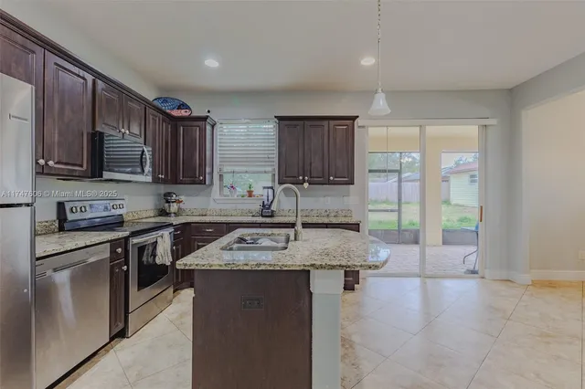 a kitchen with stainless steel appliances granite countertop a stove sink and cabinets