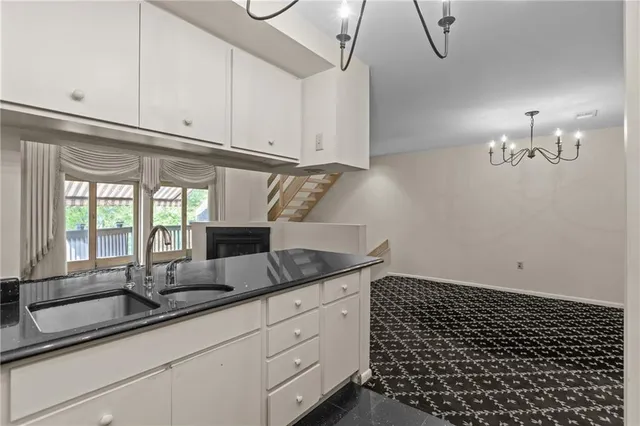 a kitchen with granite countertop white cabinets and white appliances