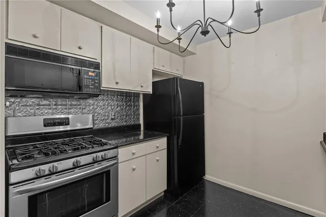 a kitchen with stainless steel appliances a stove microwave and refrigerator