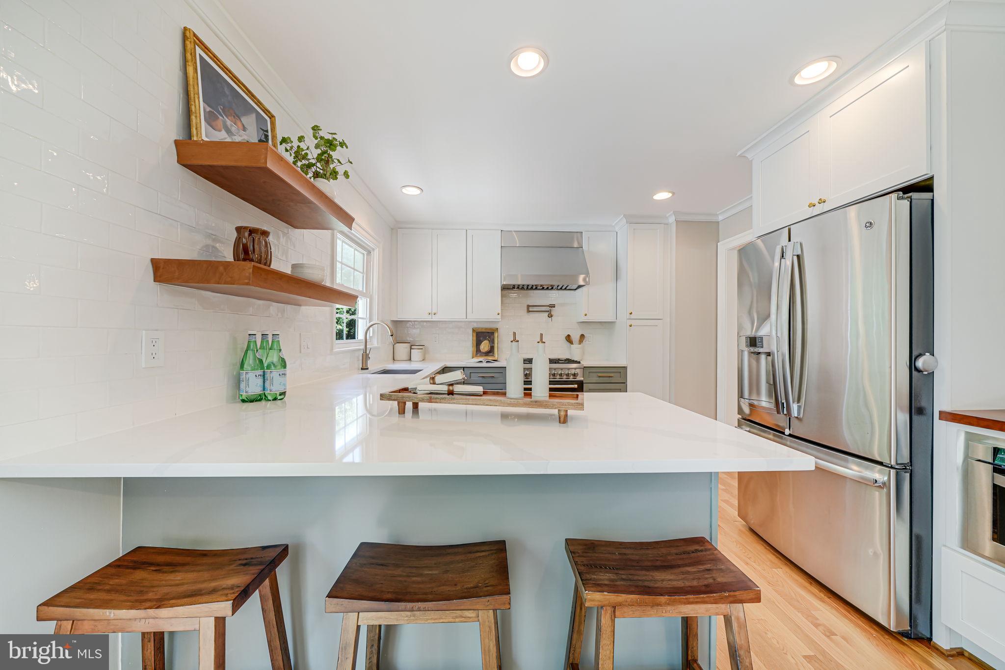1930 Foxhall Road McLean, VA 22101 - Photo 15 of 62 a kitchen with stainless steel appliances a table chairs in it and wooden floors