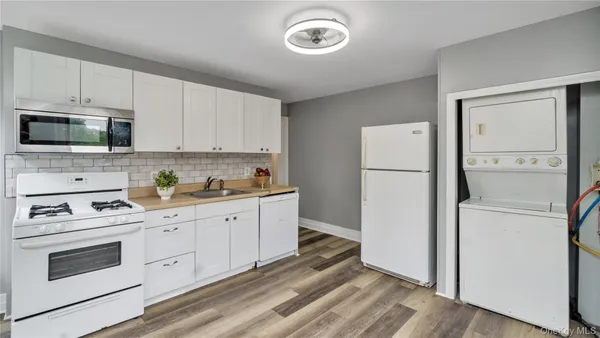 a kitchen with a refrigerator stove and white cabinets