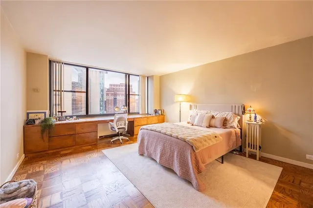 a spacious bedroom with a bed and a large window