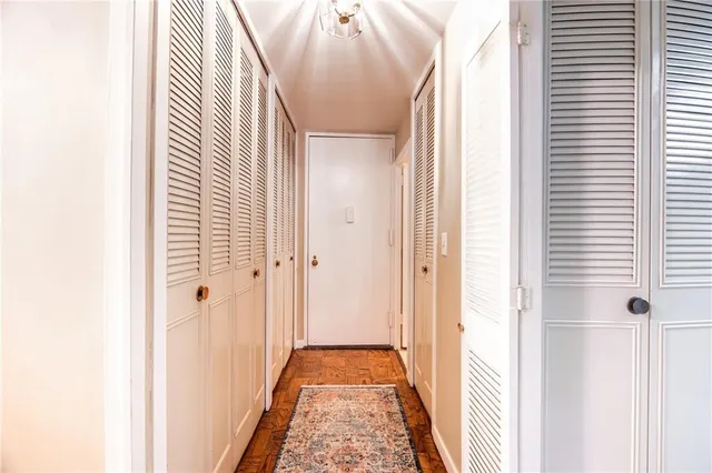 a view of a hallway with a door and a white door