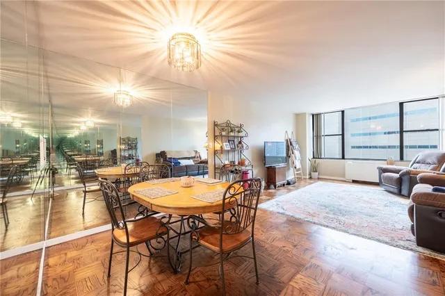 a living room with furniture a large window and a table