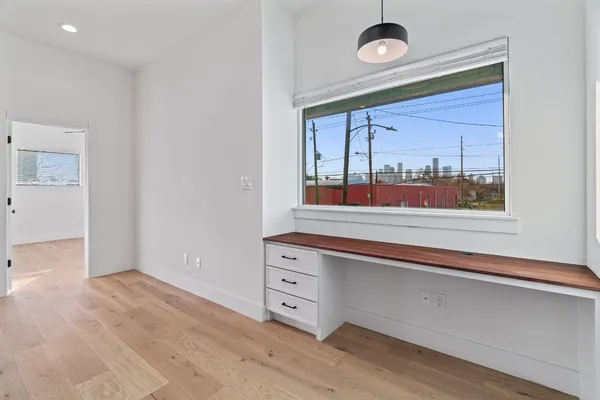 a view of empty room with wooden floor and window
