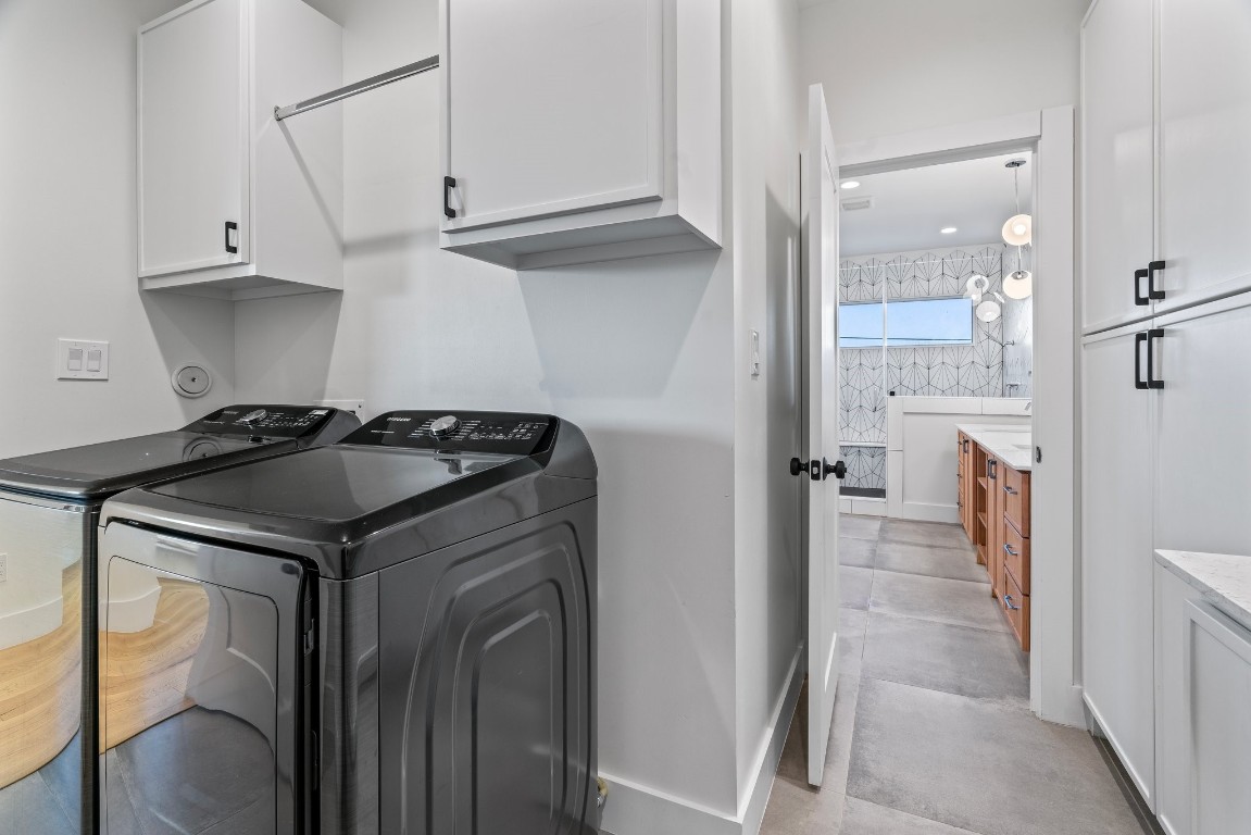 3802 Commerce Street Houston, TX 77003 - Photo 30 of 45 Through the primary retreat, we find the oversized laundry room designed for convenience and efficiency, featuring quartz countertops, a utility sink, full-size washer and dryer, high ceilings, and abundant built-in storage.