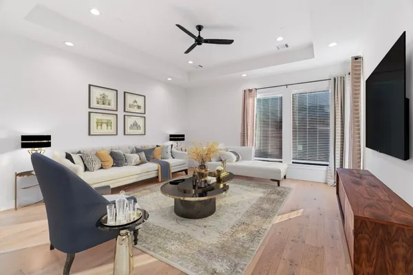 a living room with furniture a flat screen tv and a large window