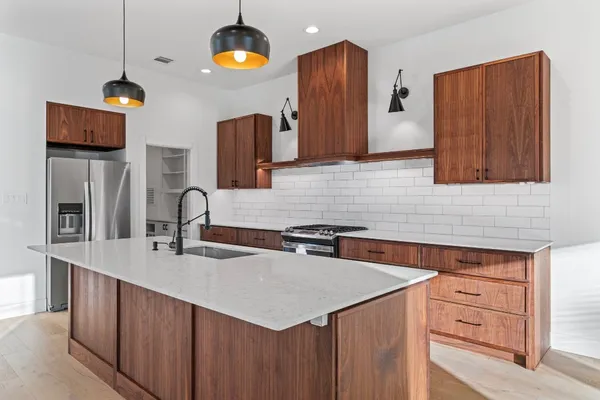 a view of kitchen with stainless steel appliances kitchen island a sink and wooden floor