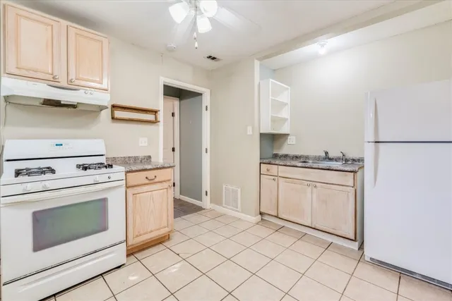 a kitchen with granite countertop white cabinets and white appliances