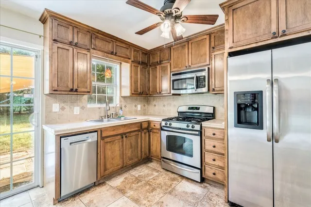 a kitchen with stainless steel appliances granite countertop a stove top oven a sink and a microwave