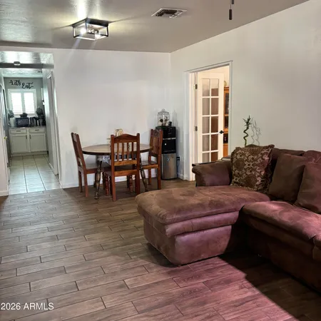 a living room with furniture a dining table and a large window