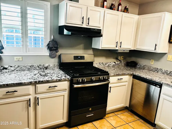 a kitchen with granite countertop white cabinets and appliances