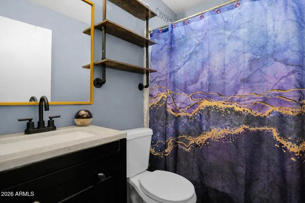 a bathroom with a sink vanity mirror and toilet