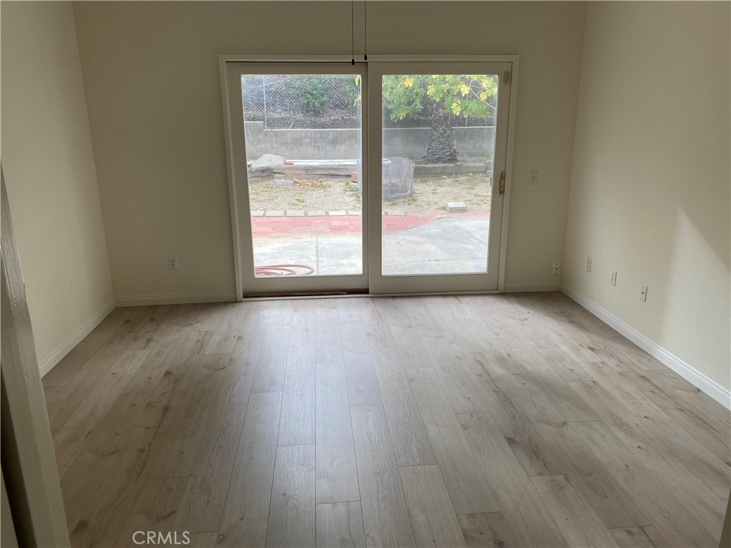 12671 Daryl Avenue Granada Hills, CA 91344 - Photo 9 of 10 a view of an empty room with wooden floor and a window
