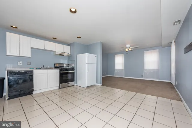 a kitchen with a refrigerator a stove top oven and cabinets
