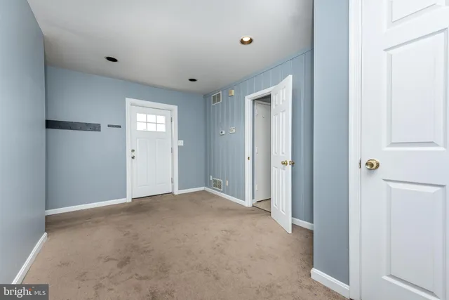 a view of an empty room with closet and a window