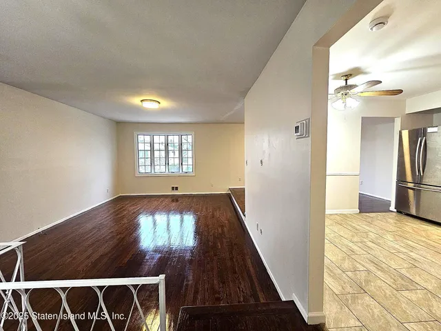 a view of a livingroom with wooden floor and a window