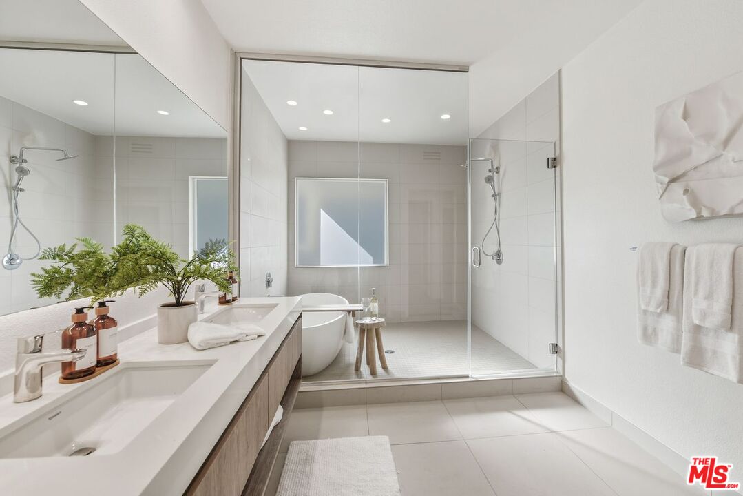 6487 Cavalleri Road, Unit 333 Malibu, CA 90265 - Photo 5 of 14 a bathroom with a double vanity sink a mirror and a shower