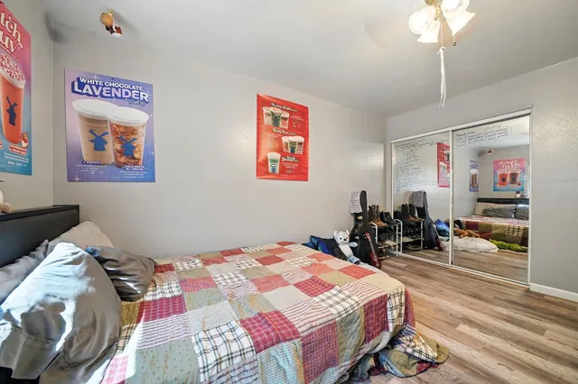 a kitchen with stainless steel appliances a stove a sink dishwasher a refrigerator with a dining table and chairs with wooden floor