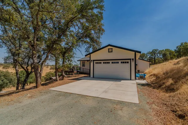 a view of a house with a yard and sitting area