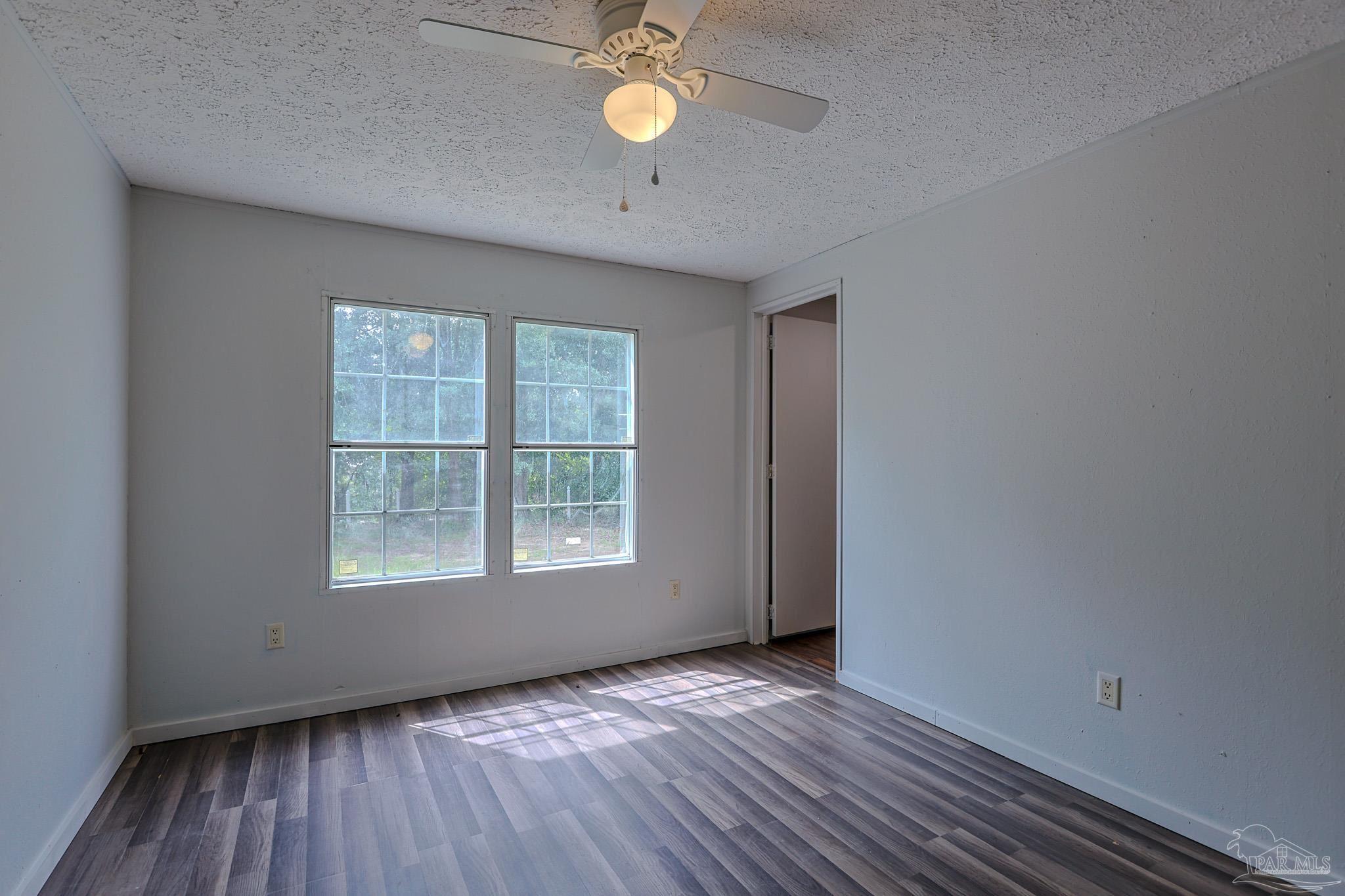 6850 Bratt Road Century, FL 32535 - Photo 28 of 57 an empty room with wooden floor and windows