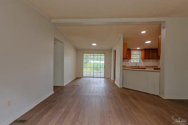 a view of a kitchen with wooden floor and a window