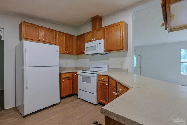 a kitchen with stainless steel appliances granite countertop a refrigerator a stove a sink and a microwave