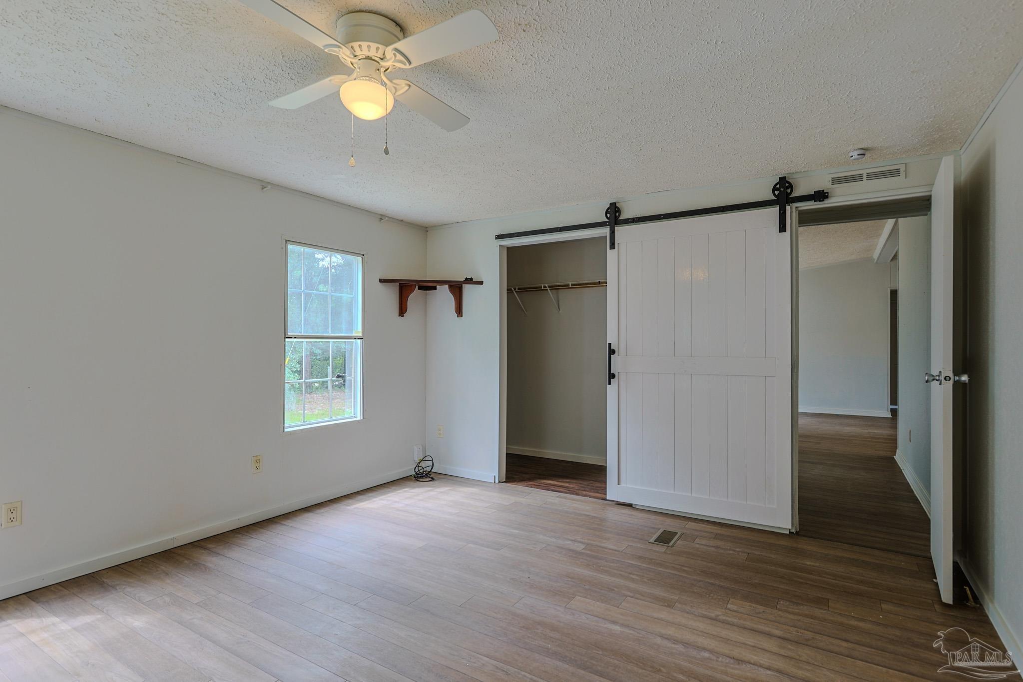 6850 Bratt Road Century, FL 32535 - Photo 45 of 57 a view of an empty room with wooden floor closet and a window