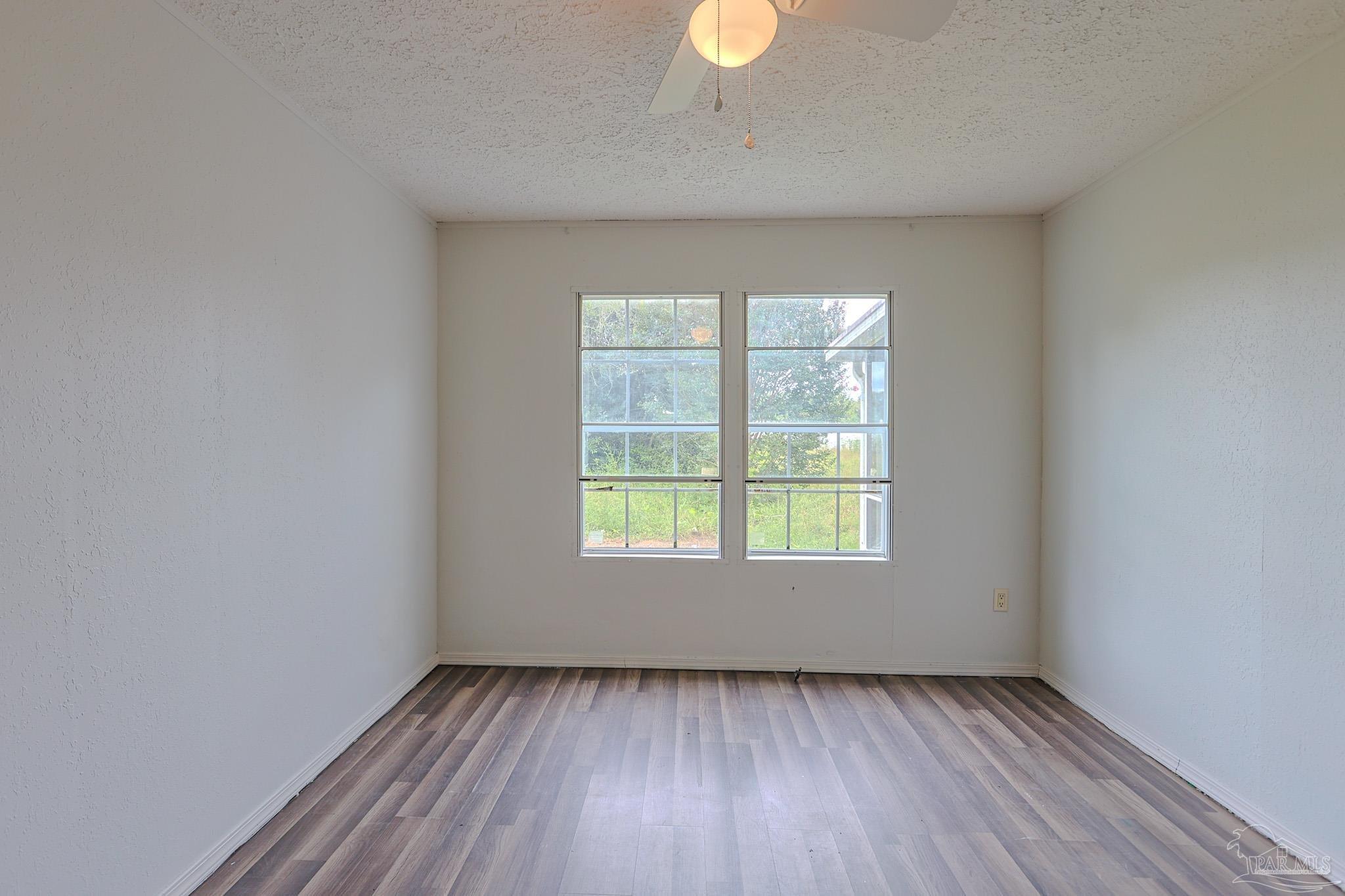 6850 Bratt Road Century, FL 32535 - Photo 5 of 57 an empty room with wooden floor and windows