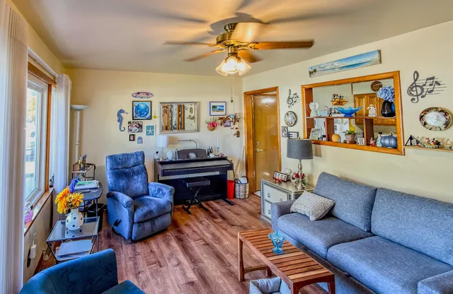 a living room with furniture a piano and a bookshelf