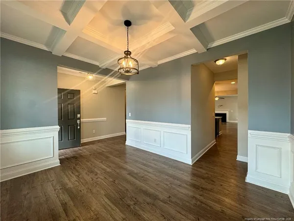 a view of a hallway with wooden floor and a chandelier