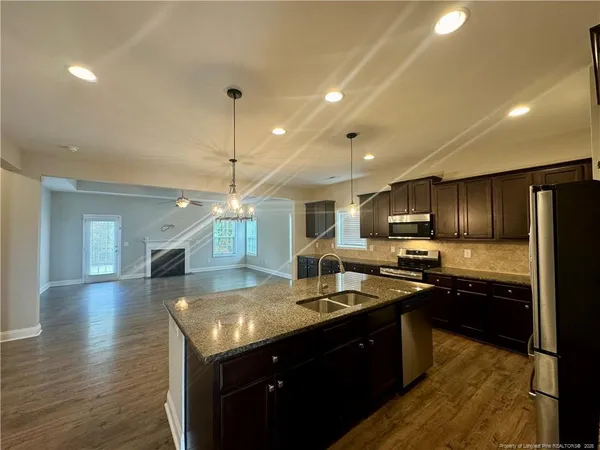 a kitchen with kitchen island granite countertop a sink counter top space and stainless steel appliances
