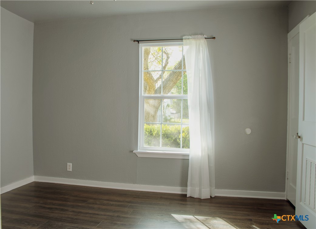 1407 South 7th Street Temple, TX 76504 - Photo 7 of 36 an empty room with wooden floor and windows