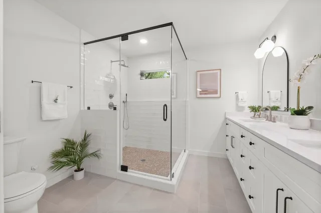 a bathroom with a double vanity sink toilet and shower
