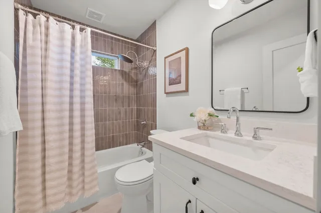 a bathroom with a sink a toilet and shower curtain