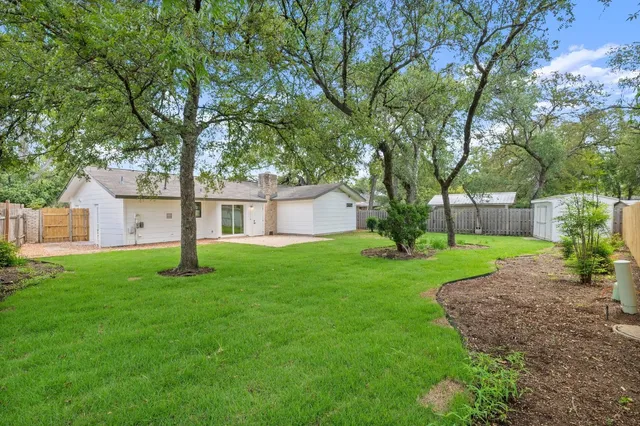a view of a house with a yard and tree